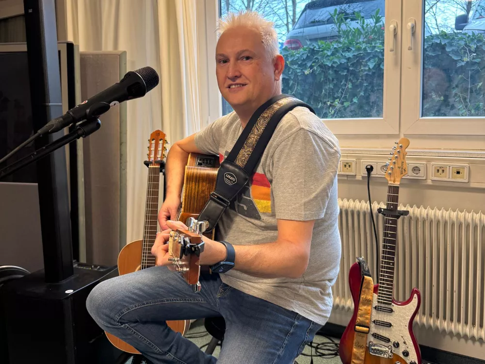 Der Vorarlberger Musiker und Liedermacher Alfred Bischof mit Akustikgitarre im Proberaum nach seinen Auszeichnungen beim Deutschen Rock & Pop Preis 2024.